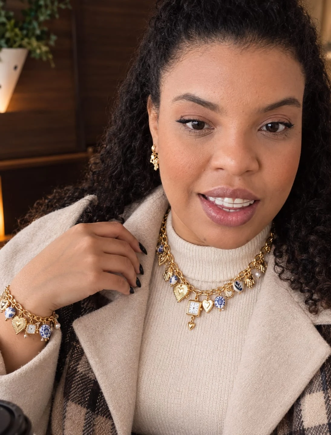 Bruna usando colar, pulseira e brincos dourados com detalhes de pérolas e pingentes